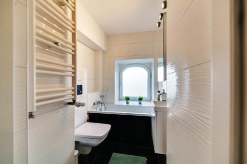 グダニスクにあるDream Loft Motlava Riverのバスルーム(洗面台、トイレ付)、窓が備わります。