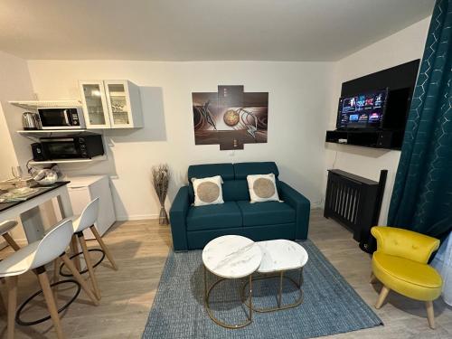 a living room with a blue couch and a table at Appartement avec vue sur jardin Paris-Disney-Parking privé 'PKN MEAUX' in Meaux