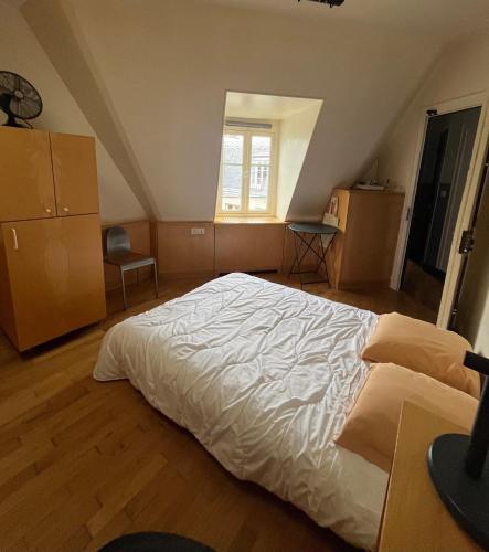 une chambre avec un grand lit blanc dans un grenier dans l'établissement Studio 6, à Paris