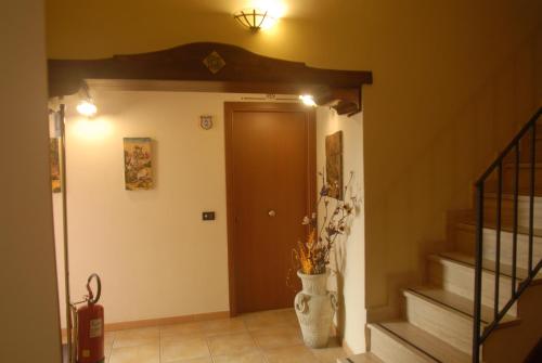 a hallway with a door and a vase with flowers at Bed and Breakfast Conte Luna in Sciacca