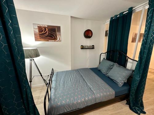 - une chambre avec un lit et des rideaux verts dans l'établissement Appartement avec vue sur jardin Paris-Disney-Parking privé 'PKN MEAUX', à Meaux