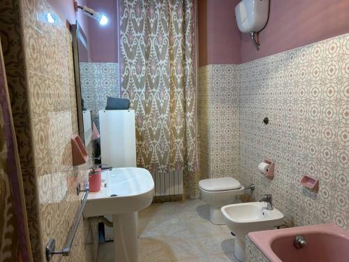 a bathroom with a sink and a toilet and a tub at Casa Mariuccia in Anzio
