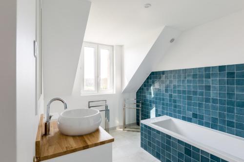 Maison de vacances & weekend lumineuse, spacieuse et au calme,- 18 personnes في Bailleul-la-Vallée: حمام مع حوض وحوض استحمام مع بلاط أزرق