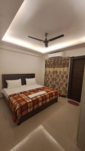 1 dormitorio con 1 cama y ventilador de techo en Gokul 3BHK Service Apartment Bharat City Ghaziabad near Hindon Airport en Ghaziabad