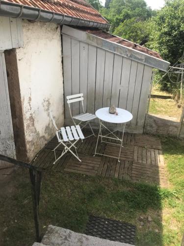 a table and two chairs on a wooden deck at Domaine La Bonne Dame - Hirondelle, au coeur des Vosges in Plainfaing