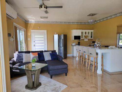 Villa Panorama في خليج مونتيغو: غرفة معيشة ومطبخ مع أريكة وطاولة