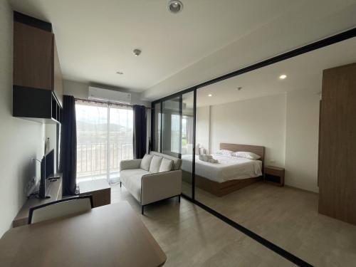 een slaapkamer met een bed en een bank in een kamer bij Downtown In Huahin la casita in Hua Hin