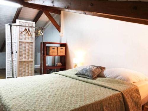 um quarto com uma cama com um cobertor em Villa Kylise em Baie-Mahault