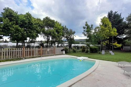une piscine avec deux chaises et une clôture dans l'établissement Chambre d'Hotes Manon - Domaine Les Peupliers -, à Lagnes