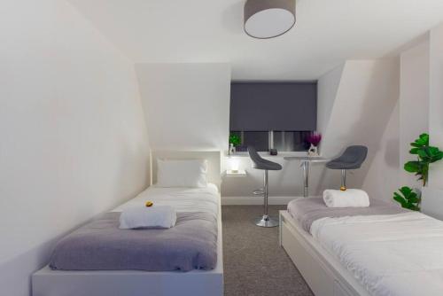a room with two beds and a chair in it at Parade Paradise- Secret Views, LEDs, 4K TVs, 5G WIFI and more! in Bath