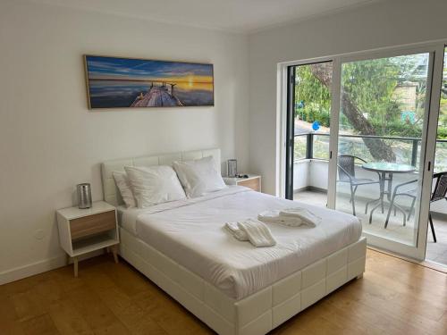 a bedroom with a bed and a balcony with a table at Large double room 2 with en-suite bathroom and Belcony in Oeiras