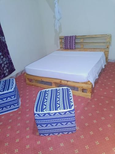 łóżko i 2 otomany w pokoju w obiekcie Jamagere Homes near Palm Oasis w mieście Garissa
