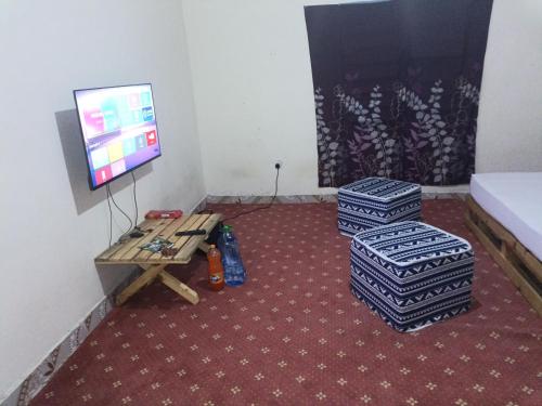 Pokój z telewizorem, 2 kanapami i stołem w obiekcie Jamagere Homes near Palm Oasis w mieście Garissa