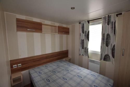 une petite chambre avec un lit et une fenêtre dans l'établissement CAMPING GASTES 617b, à Gastes