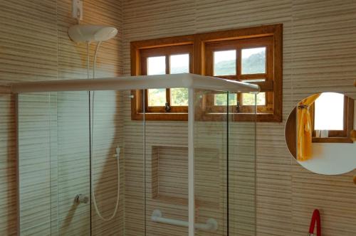 a bathroom with a shower with a glass shower at Blue House Vale do Capão in Palmeiras