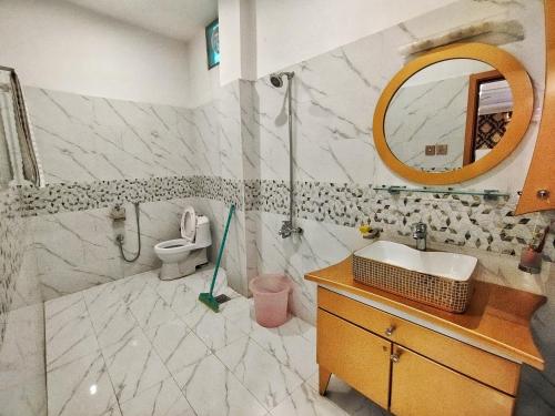 uma casa de banho com um lavatório e um espelho em Swat Hilton Hotel by Khan Familia em Suat