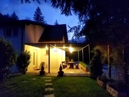 a house with a lit up patio at night at Riverside Guesthouse in Ig