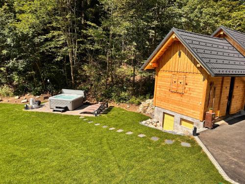 a small wooden building with a boiler in a yard at The Vila Bled Premium Luxury Retreat in Bled