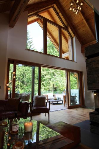 a living room with large windows and a fireplace at The Vila Bled Premium Luxury Retreat in Bled