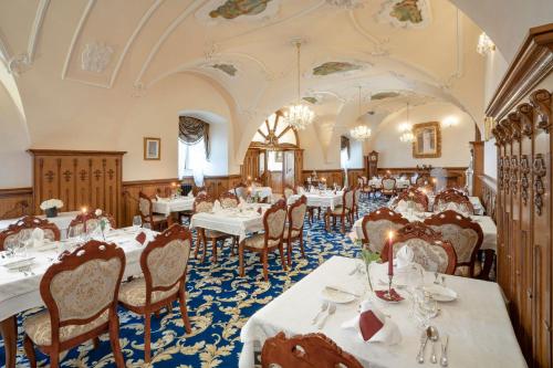 a dining room with white tables and chairs at Galicia Nueva, castle hotel in Lučenec