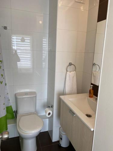 een witte badkamer met een toilet en een wastafel bij Brisas in Talcahuano