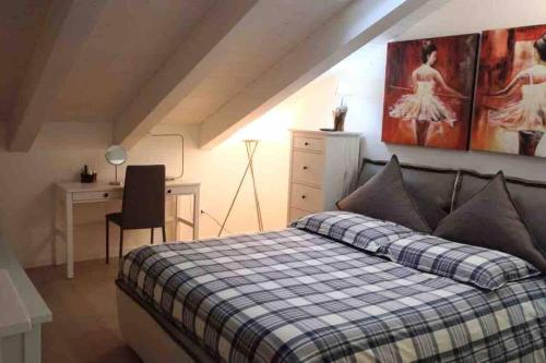 ein Schlafzimmer mit einem Bett, einem Schreibtisch und einem Gemälde in der Unterkunft Casa annuale al mare a Jesolo! in Lido di Jesolo
