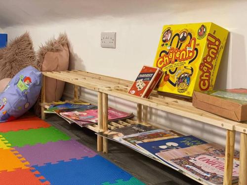 a room with a wooden table with games on it at Santiago Suite 4 - A Beautiful Duplex Flat in Southport