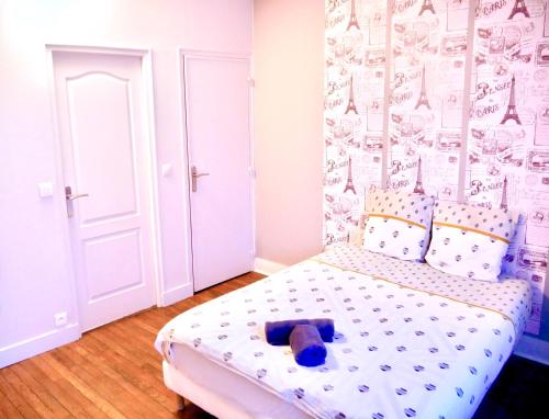 une chambre avec un lit avec un ours en peluche dessus dans l'établissement Family Home, à Sens