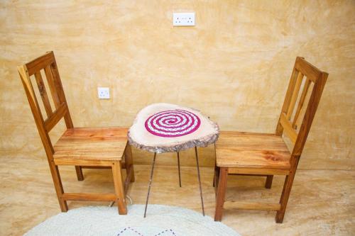 Dos sillas y una mesa con una cebolla púrpura. en Zanzigo, en Nungwi