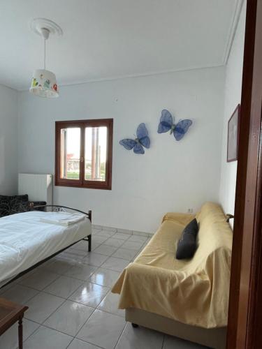 a bedroom with two beds and butterflies on the wall at My Sweet Home in Tríkala