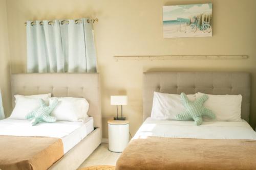a bedroom with two beds and a table with a lamp at The Nest Villa, A Dream Escape for the entire family in Golden Grove