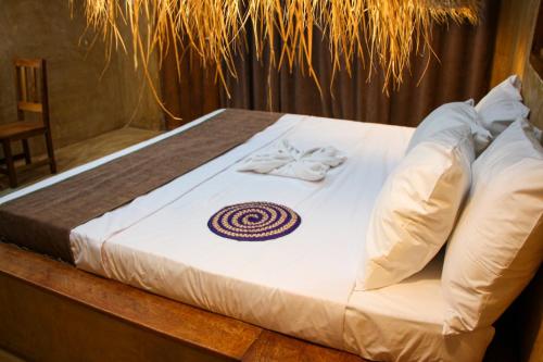 a bed with white sheets and white shoes on it at Zanzigo in Nungwi