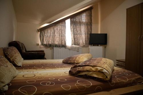 ein Schlafzimmer mit einem Bett mit Kissen und einem Fenster in der Unterkunft Pensiunea FADI in Lugoj