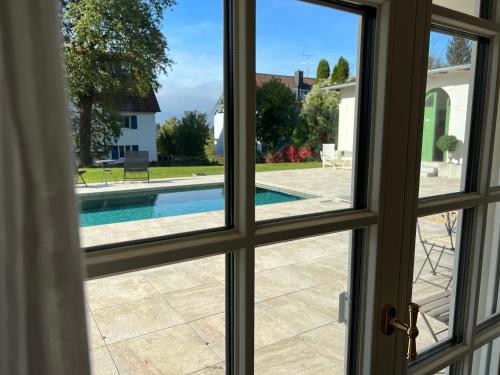 a window view of a swimming pool from a house at Villa Rosenhof (2 Personen +) in Lindau