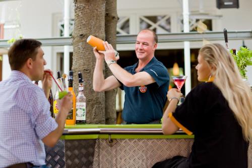 a man standing at a bar holding a bottle of wine at Hotel Villa Neander in Binz
