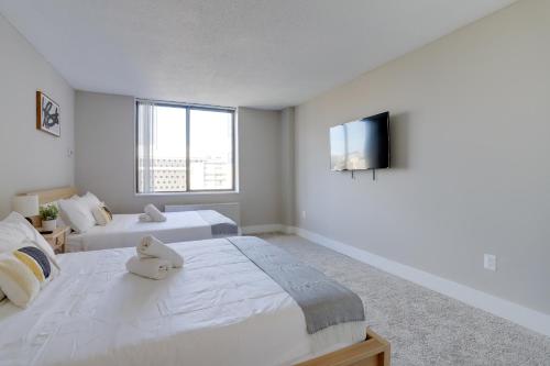 a bedroom with two beds and a flat screen tv at Elegance in Crystal City - Amazing Apartment with gym in Arlington