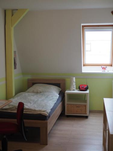 um quarto com uma cama e uma janela em Jarmen Ferienwohnung em Jarmen