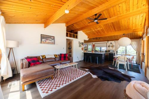 uma sala de estar com um sofá e uma mesa em Yosemite A-Frame Haven - Nature's Embrace for Remote Work or Relaxation em Groveland
