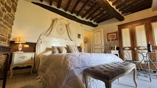 a bedroom with a large bed and a chair at Residenza Teatro Antico in Todi