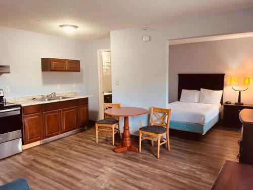 a hotel room with a bed and a kitchen with a table at Palace Inn & Suites - Newport News/Jefferson Ave in Newport News