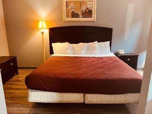Palace Inn & Suites - Newport News/Jefferson Ave في نيوبورت نيوز: غرفة فندق بسرير لحاف احمر
