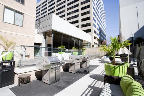a patio with a grill and tables and a building at Elegance in Crystal City - Amazing Apartment with gym in Arlington