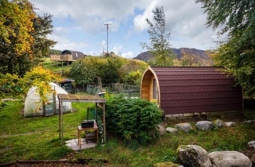 a garden with a small building and a greenhouse at Spectacular Mountain View Ecopod in Newtonmore