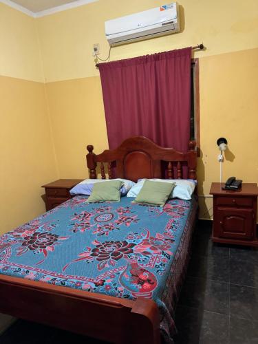 a bedroom with a bed with a blue comforter at Hotel y Departamentos Arroyos in Perico