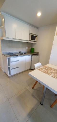 a kitchen with white cabinets and a table and a stove at DEPTO LAVALLE 1191 PLAZA BELGRANO in San Miguel de Tucumán