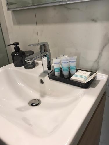 a tray with cups and books on a bathroom sink at Daphne Luxe Retreat -Sea View-King size bed- in Supetar