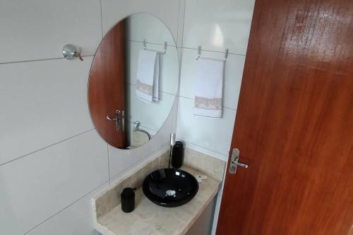 a bathroom with a black sink and a mirror at Apartamento Praia do Sonho in Palhoça