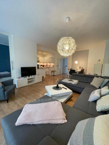 a living room with a couch and a tv at Deluxe Apartment mit Stil und Carport Stellplatz in Oldenburg