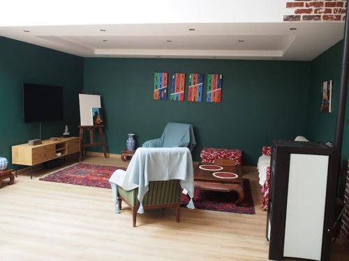 sala de estar con mesa y paredes verdes en Loft des Célestins, en Vichy