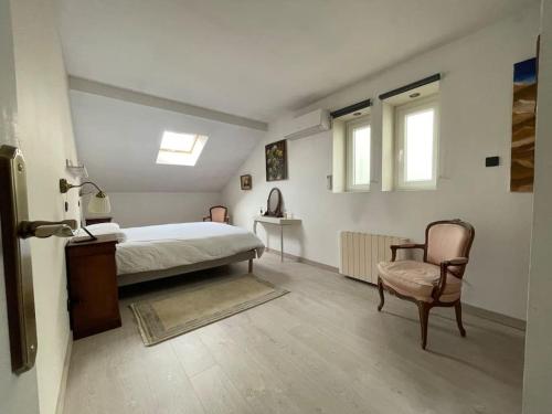 1 dormitorio con 1 cama y 1 silla en Loft des Célestins, en Vichy